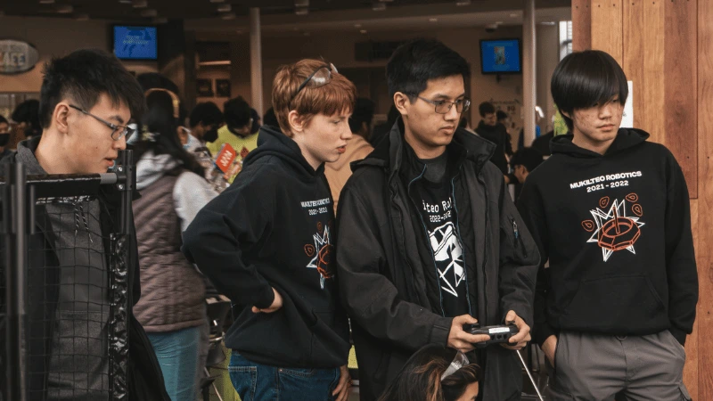 This is a photo of two teammates getting their robots inspected at a competition.